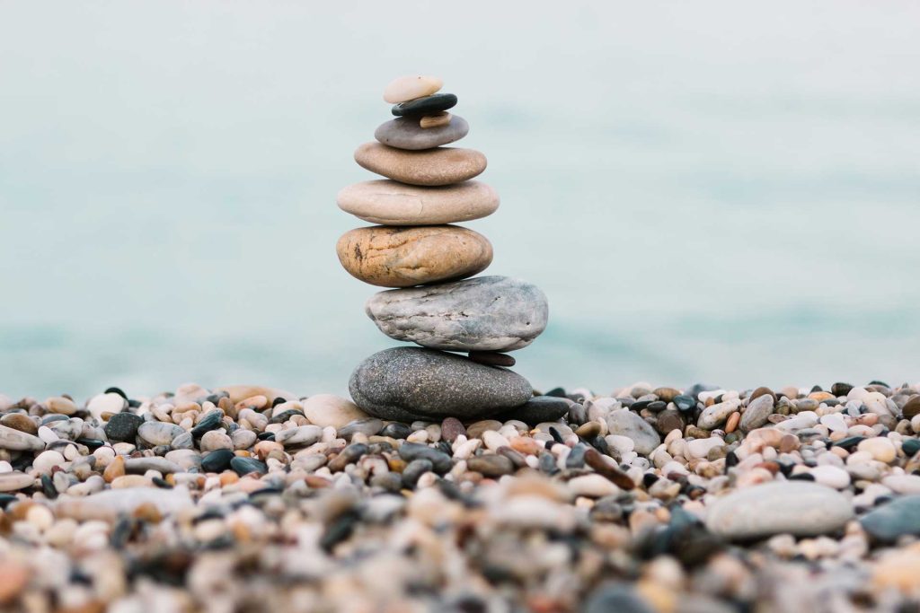 Pebbles stacked on beach | About Reilly Counseling CEnter